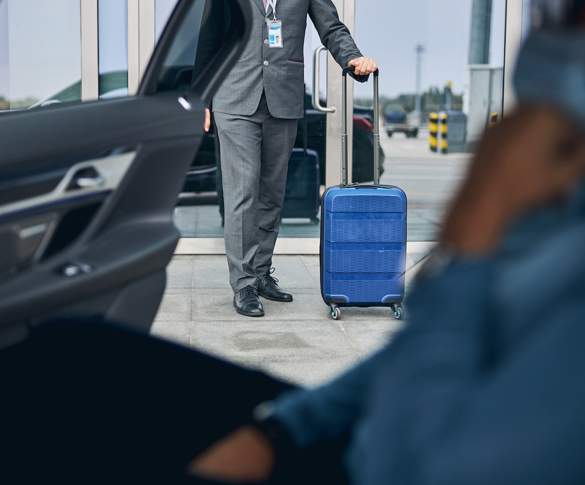 Cropped photo of a Caucasian man in a face mask waiting for his private driver